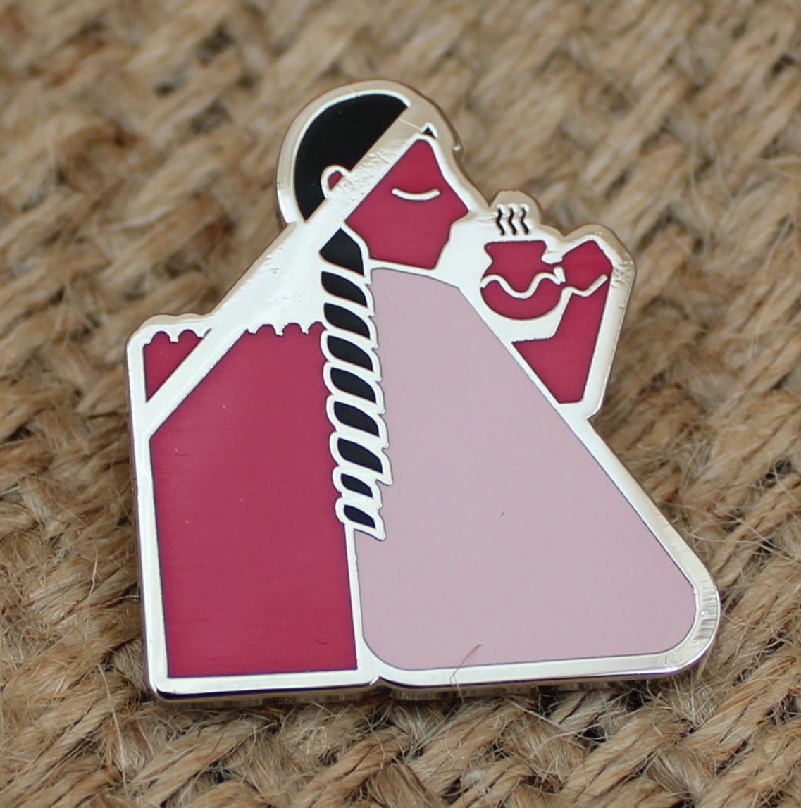 Pin with a design on a textured brown fabric background