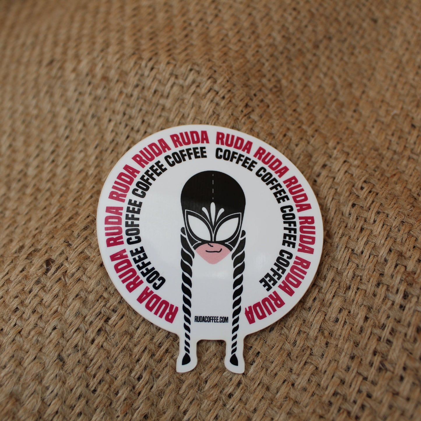 Circular sticker with a character design and text on a textured brown background